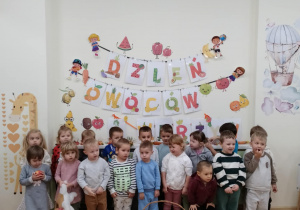 Zdjęcie grupowe dzieci z grupy Kamyczki z koszami owoców i warzyw.