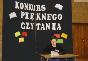 Uczeń kl. VI czyta fragment książki pt. ,,Drzewo do samego nieba”.