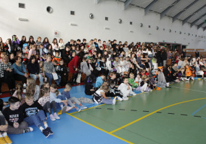 Uczniowie siedzą na trybunach i w czekają na wyniki konkursów.