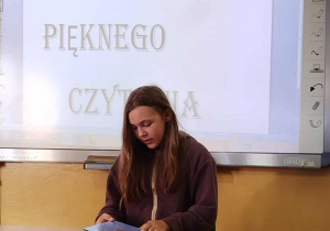 Uczennica kl. VI czyta fragment tekstu z książki pt. ,,Polskie miasta w baśni i legendzie” Barbary Tylickiej.