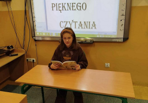 Uczennica kl. IV czyta fragment książki pt. ,,Jacek, Wacek i Pankracek” Miry Jaworczakowej.