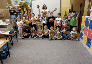 Grupowe zdjęcie żabek z dyniami.