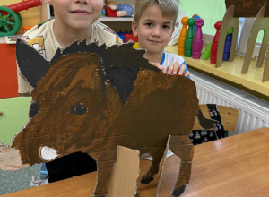 Chłopcy z grupy Żabki z dzikiem wykonanym z tektury.