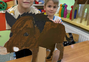 Chłopcy z grupy Żabki z dzikiem wykonanym z tektury.