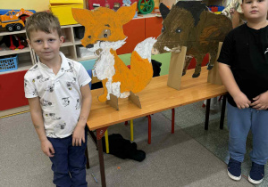 Dwóch chłopców z liskiem i dzikiem z tektury.