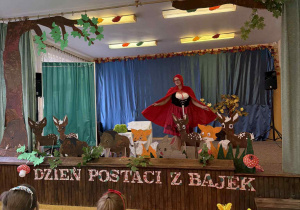 Pani Ola stoi na scenie w przebraniu Czerwonego Kapturka.