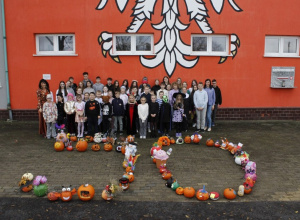 Uśmiechnięci i zadowoleni uczniowie pozują ze swoimi pracami wraz z Dyrektorem szkoły i opiekunem Samorządu Uczniowskiego.