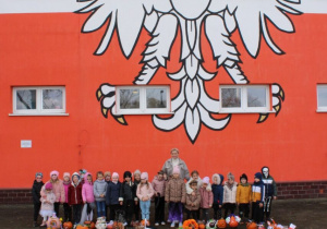 Uśmiechnięte dzieci z oddziału przedszkolnego pozują z przepięknymi dyniami.