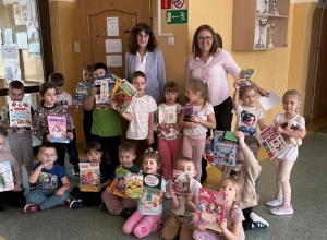 Przedszkolaki ze Szkoły Filialnej w Sadykierzu stoją przed biblioteką z zakupionymi książkami. Z przedszkolakami jest wychowawczyni i bibliotekarka.