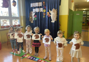 Dziewczynki z grupy Szkraby prezentują "kolczastego zwierza" malowanego farbami.