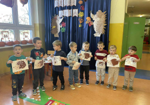 Chłopcy z grupy Szkraby trzymają w dłoniach prace plastyczną - jeża malowanego farbami plakatowymi.