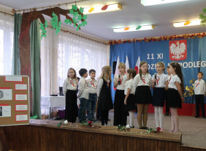 Uczniowie śpiewają piosenkę „Wojenko, Wojenko” w strojach galowych.