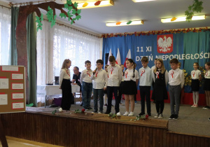 Uczniowie w galowych strojach recytują wiersze.