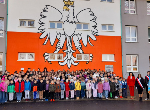 Uczniowie klas I - VIII wraz z Panią Dyrektor i Sztandarem Szkoły stoją przed szkoła i śpiewają hymn polski
