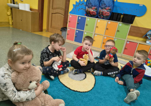 Dzieci z grupy Słoneczka przytulają pluszowe zabawki.