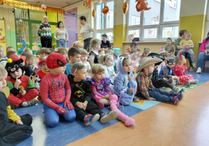 Dzieci w strojach bajkowych z zaciekawieniem oglądają przedstawienie przygotowane przez dzieci w Dniu Postaci z Bajek.