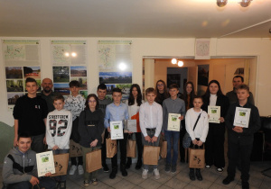 Zdjęcie przedstawia wszystkich Uczestników Konkursu ze Spalskiego i Sulejowskiego Parku Krajobrazowego wraz z organizatorami. Laureaci trzymają w ręku dyplomy i nagrody umieszczone w papierowych torbach.