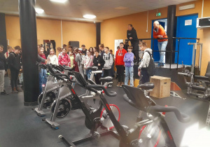 Uczniowie i opiekunowie w siłowni dla siatkarzy.