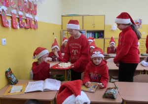 Uczennice z Samorządu Uczniowskiego częstują uczniów klasy pierwszej świeżymi owocami.