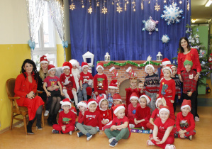 Zdjęcie grupowe dzieci 4-5 latków z wychowawcą w towarzystwie św. Mikołaja oraz z panią Dyrektor i Zastępcą Wójta.