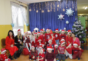 Zdjęcie grupowe dzieci z grupy Skoczki z panią Dyrektor, Zastępcą Wójta oraz św. Mikołajem.