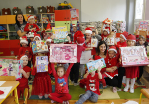 Dzieci z grupy Promyczki z radością prezentują otrzymane prezenty z okazji Mikołajek.