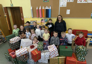 Grupa Żabki z zapakowanymi i udekorowanymi kokardami prezentami.