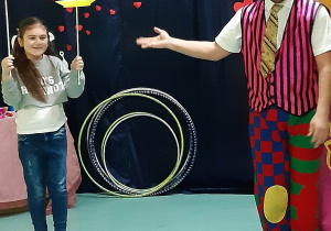 Ola żongluje talerzami obok stoi artysta