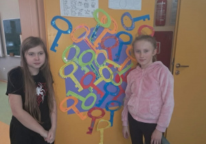 Uczennice klasy 4 przy dekoracji andrzejkowej na drzwiach klasy.