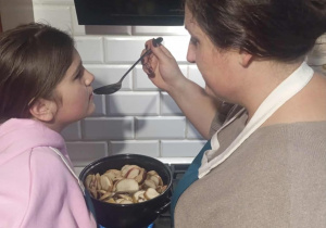 Uczennica z mamą w kuchni przygotowuje andrzejkową potrawę.