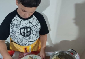 Chłopiec przygotowuje andrzejkową potrawę.