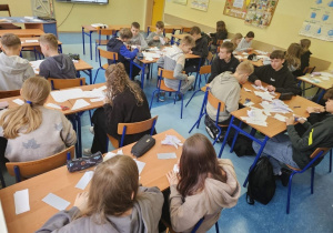 Uczniowie składają sześcian z papierowych modułów.