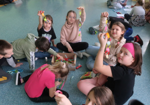 Uczennice prezentują swoje kawałki łańcucha papierowego.