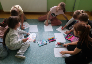 Uczennice podczas kreatywnego kolorowania papierowych bombek.