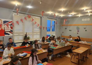 Uczniowie klasy 5 projektują swoje kartki w świątecznie udekorowanej pracowni językowej