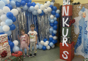Chłopiec i dziewczynka na tle ścinaki balonowej i obrazu Pani Zimy.