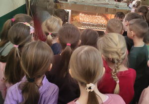 Dzieci przyglądają się jak bombki są posrebrzane i stają się błyszczące.