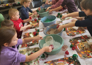 Pierwszaki wykonują bombki z wykorzystaniem różnych ozdób.