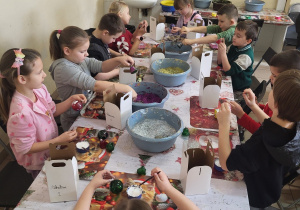 Uczniowie pakują do pudełka swoje własnoręczne wykonane ozdoby.