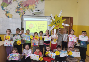 Uczniowie klasy pierwszej prezentują swoje prace z okazji Dnia Życzliwości i Pozdrowień.