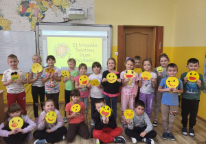 Pierwszaki trzymają w ręku wykonaną prace – Uśmiechnięte buźki.