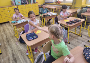 Dziewczynki wykonują miły gest.