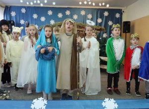 Grupa uczniów przedstawiających jasełka podczas śpiewania kolędy.