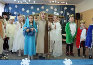 Grupa uczniów przedstawiających jasełka podczas śpiewania kolędy.