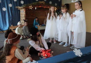 Pastuszkowie i aniołowie na scenie przestawiający swoje role.