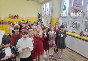 Pierwszaki trzymają w ręku opłatek.