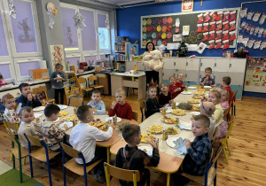 Spotkanie wigilijne przy świątecznym stole połączone ze śpiewaniem kolęd.