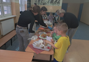 Uczennice kl. VIII a i VIII b sprzedają owoce oraz pierniczki przedszkolakom.