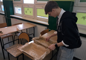 Uczeń kl. VIIIb przygotowuje w klasie ciastka do pieczenia.