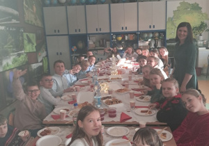 Uczniowie klasy IV wraz z wychowawcą przy wigilijnym stole.